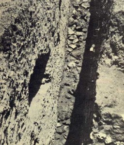 Primera trinchera de exploración realizada por Cummings y Gamio a principios de 1922. Muestra el muro de piedra del segundo talud del lado sur-oeste. Puede apreciarse que es revestimiento igual al que actualmente existe, ya que no fue recontruido.