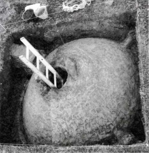 La cúpula del aljibe excavada, midiendo tres metros de lado, con sus entradas de agua en las esquinas y el pozo central para el brocal del balde. Bajo el excavador se ve el único albañal de mampostería encontrado.